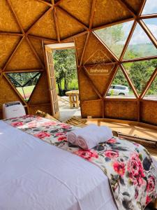 Habitación con cama en una yurta con ventana en Ecofuratena Glamping & Experience en Utica