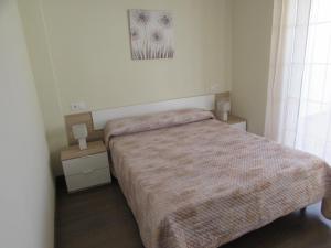 um pequeno quarto com uma cama e duas mesas de cabeceira em Luz y Mar Huelva-Ático em Huelva