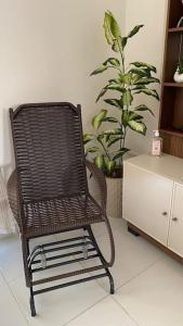 a rattan chair in a room with a plant at Brisas do Lago in Paulo Afonso