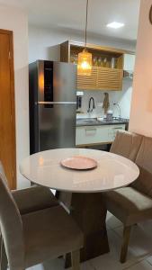 eine Küche mit einem weißen Tisch und einem Kühlschrank in der Unterkunft Brisas do Lago in Paulo Afonso
