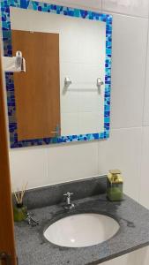 ein Bad mit einem Waschbecken und einem Spiegel in der Unterkunft Brisas do Lago in Paulo Afonso