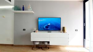 un televisor sentado en una cómoda blanca en una sala de estar en Sweet Sunset Playa del Cura, en Mogán