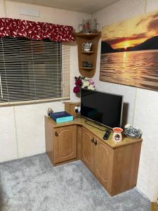 a living room with a television on a wooden desk at Tummel 2 in Forfar