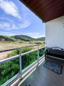 a balcony with a bench and a view at Norshah Village Resort in Pantai Cenang