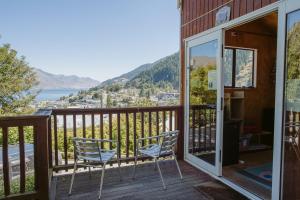 two chairs on a deck with a view of the water at Hippo Lodge Backpackers in Queenstown