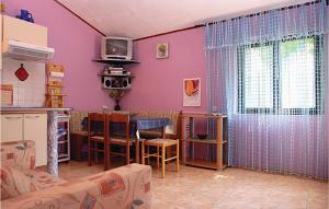 a living room with purple walls and a table and a kitchen at Awesome Apartment In Medulin With Wifi in Medulin