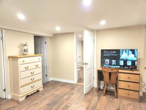 a bedroom with a dresser and a desk with a tv at Cozy spacious Apt In Laval, Greater Montreal in Laval
