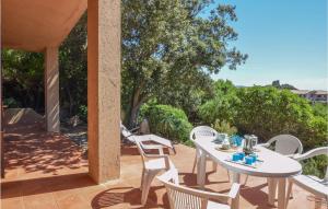 una mesa blanca y sillas en un patio en Nice Home In Trinita Dagultu Vignol With Kitchen, en Li Valcaggi