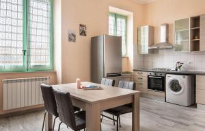 una cucina con tavolo, sedie e frigorifero di 2 Bedroom Gorgeous Apartment In Guspini a Guspini