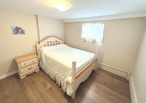 um pequeno quarto com uma cama e uma janela em Cozy spacious Apt In Laval, Greater Montreal em Laval