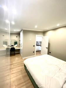 a bedroom with a large white bed and a desk at Rooftop Sunset View Apartment in Tirana