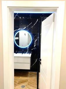 a bathroom with a sink and a mirror at Rooftop Sunset View Apartment in Tirana +12 photos