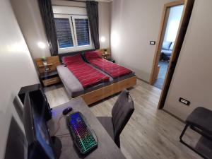 a bedroom with a bed and a desk with a computer at Apartma Auriga in Portorož