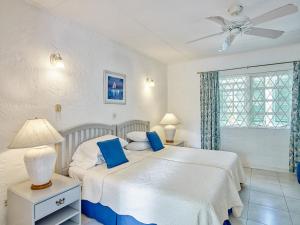 1 Schlafzimmer mit 2 Betten und einem Deckenventilator in der Unterkunft Southwinds Villa is a three bedroom beach front property with a beautiful big in in Saint Peter