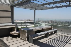 a balcony with benches and a view of a city at Rentaparts Sucursal Manquehue in Santiago