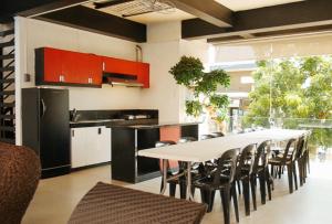 a kitchen with a long table and chairs in a room at Casa Demetria Duplex Hot Spring Resort Laguna in Pansol