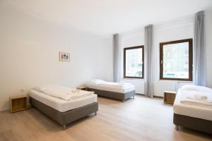 Habitación con 2 camas y 2 ventanas. en RAJ Living - 4 Room Apartments - 30 Min Messe DUS, en Duisburg