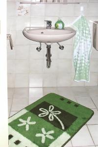a bathroom with a sink and a green rug at Cottage, Jagdhof in Judenbach