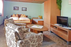 a living room with a couch and a television at Cottage, Jagdhof in Judenbach