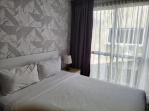 a bedroom with a white bed and a window at SRITEL BOUTIQUE HOTEL in Shah Alam