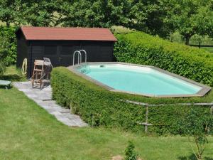 a swimming pool in a hedge next to a building at Snug Holiday Home in Chambourg Sur Indre with Pool in Chambourg-sur-Indre