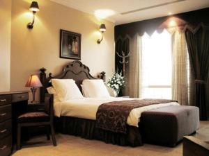 a bedroom with a large bed and a window at Milan Deluxe Suites in Al Khobar