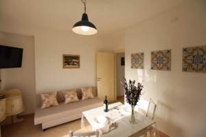 ein Wohnzimmer mit einem Sofa und einem Tisch in der Unterkunft Bilocale Conca in villa climatizzata - Wi-fi in pieno rekax in Marzamemi