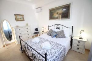 Schlafzimmer mit einem schwarzen und weißen Bett und einem Spiegel in der Unterkunft Bilocale Conca in villa climatizzata - Wi-fi in pieno rekax in Marzamemi