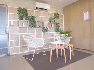 een wachtkamer met stoelen en een tafel en planken bij Swiss-Belexpress Cilegon in Cilegon