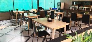 een restaurant met tafels en stoelen in een kamer bij Coastal Bay Inn By Gemstone Hospitality in Alibaug
