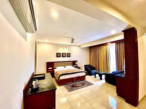 a hotel room with a bed and a desk at Kamat's Hilltop Leisure in Dona Paula