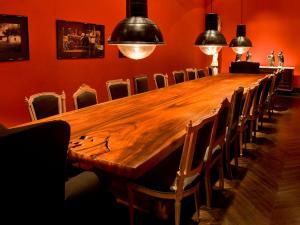 een lange houten tafel in een kamer met stoelen bij La Alondra, Casa de huéspedes in Corrientes