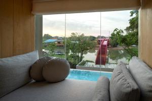 a living room with a couch and a large window at Sala Bang Pa-In in Phra Nakhon Si Ayutthaya