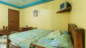 ein Schlafzimmer mit einem Bett und einem TV an der Wand in der Unterkunft RGV Beach Resort Batangas in Calatagan