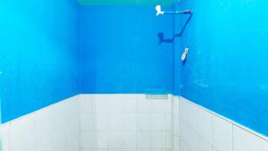 a bathroom with a blue wall and a shower at RGV Beach Resort Batangas RedPartner in Calatagan