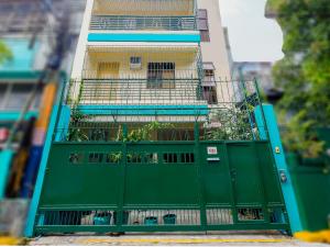 a green gate in front of a building at OYO 840 Orangenest Apartelle in Manila