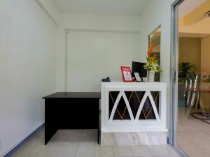 una stanza con un armadietto bianco e un tavolo nero di OYO 840 Orangenest Apartelle a Manila