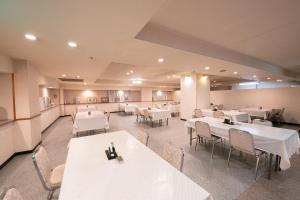 een eetkamer met witte tafels en stoelen bij Main Hotel - Vacation STAY 82545 in Miyakonojo