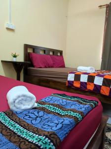 two beds in a room with two bedsskirts at Kubang Kerian DECO HOMESTAY Aircond Wifi Netflix in Kota Bharu