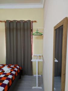 a bedroom with a bed and a curtain and a table at Kubang Kerian DECO HOMESTAY Aircond Wifi Netflix in Kota Bharu
