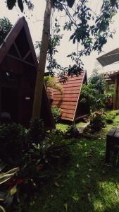 a house with a wooden roof in a yard at Bliss family cottage Batu in Batu