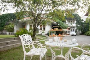 a white table and chairs in front of a house at Ru Boutique in Kandy