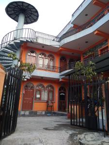 um edifício laranja com um portão em frente em Paramount guest house em Pokhara