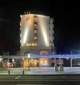 a tall building with a blue beam in front of it at Hyper Hotel Komatsu in Komatsu