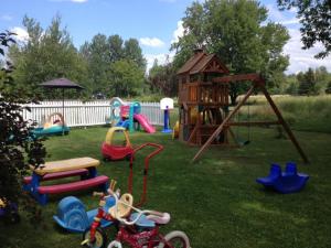 un parque infantil con diferentes tipos de equipos de juego en un patio en Studiotel Bromont, en Bromont