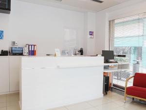an office with a white counter and a red chair at San Remo in Alicante