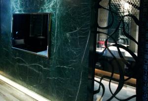 un espejo en el lateral de una pared con una mesa en The Yorker Deluxe Motel en Taoyuan