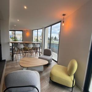 ein Wohnzimmer mit Stühlen, einem Tisch und einem Esszimmer in der Unterkunft The Originals City, Hôtel Les Dômes, Perpignan Sud Saleilles in Perpignan