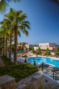 basen z palmami w ośrodku w obiekcie Grand Hotel Holiday Resort w mieście Hersonissos