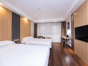 a hotel room with two beds and a flat screen tv at Country Inn&Suites by Radisson, Shanghai PVG in Shanghai